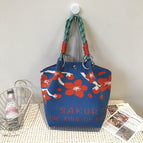 Handbag with cherry blossoms on blue background
